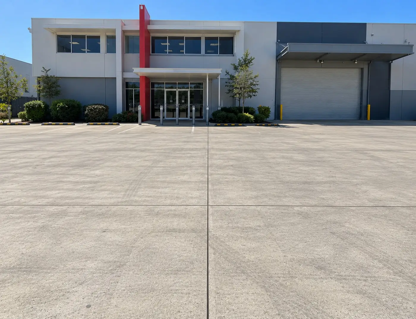 Large concrete hardstand with control joints outside a commercial warehouse
