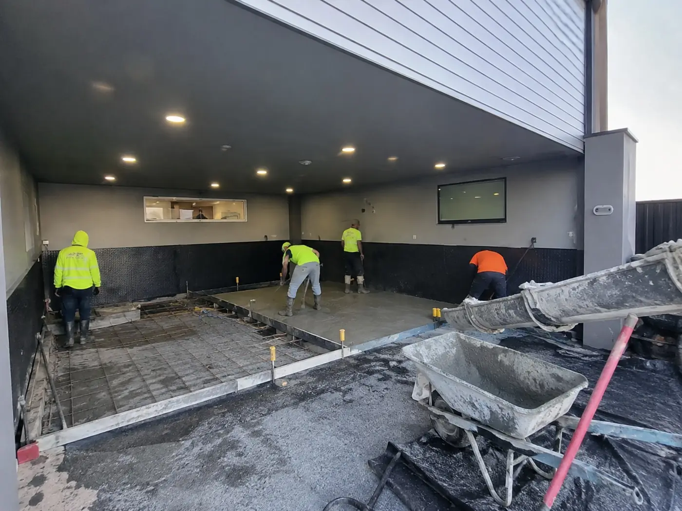 Concreters screeding a commercial tenancy floor slab in Wollongong